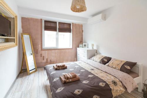 a bedroom with a large bed and a mirror at Domus Apartments City Center in Plovdiv