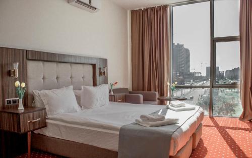 a hotel room with a bed and a large window at Legend Business Hotel Batumi in Batumi