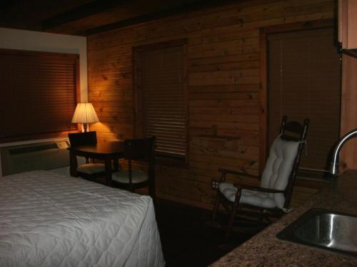 una camera con letto, tavolo e lavandino di Cool Springs Inn a Michigan City
