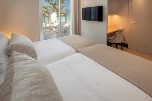 a bedroom with a large white bed and a desk at Bel Air in Castelldefels