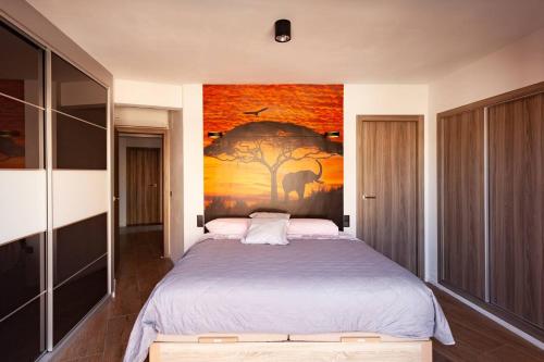 カルプにあるParadero Rental PS-Vistas al Marのベッドルーム1室(壁に絵画が描かれたベッド1台付)