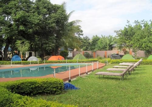 姆托瓦姆布的住宿－無花果經濟型酒店，旁边一排长椅,旁边是一个带帐篷的游泳池