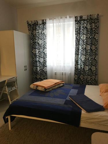 a bedroom with a bed and a window with curtains at Дом in Kyiv