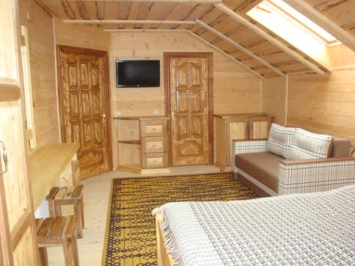 a bedroom with a bed and a tv in a room at Eco Sadyba Familia in Yaremche