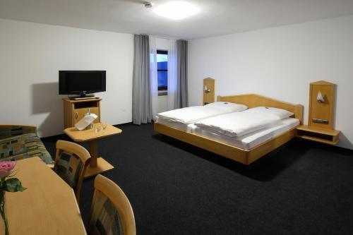 a hotel room with a bed and a tv at Spirklhof in Bodenkirchen