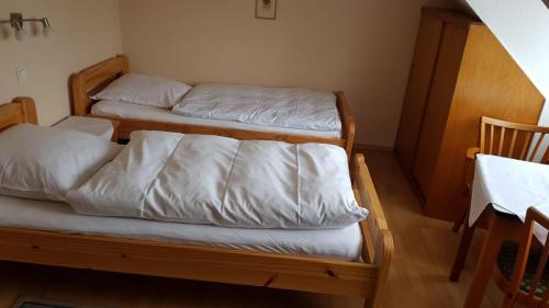 2 Etagenbetten mit weißer Bettwäsche in einem Zimmer in der Unterkunft Gasthaus Schug-Müller in Flacht