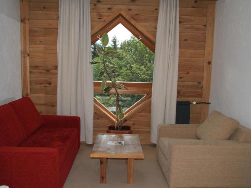 a living room with a red couch and a window at Bianca Resort & Spa in Kolašin