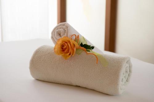 a towel with a flower on it sitting on a bed at Luitpoldpark-Hotel in Füssen