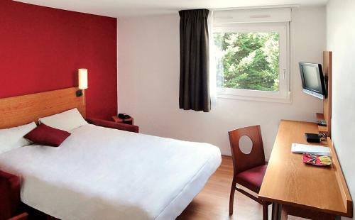 a bedroom with a white bed and a desk and a window at Séjours & Affaires Bordeaux de L'Yser in Bordeaux