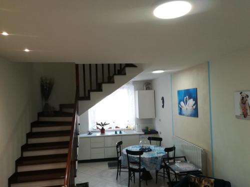 a kitchen and a staircase in a room with a table at Affittacamere Lo Scoiattolo di Mannocchi Lorella in Porto SantʼElpidio