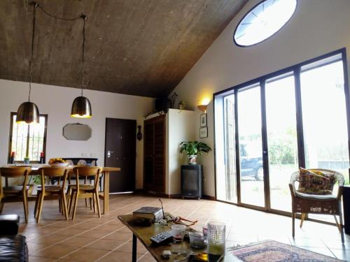 ein Wohnzimmer mit einem Tisch und einem großen Fenster in der Unterkunft Casa los Jinetes in Carmona