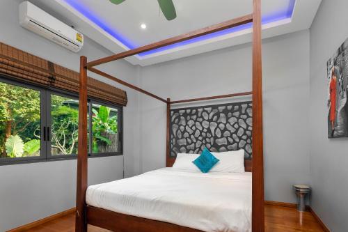 a large bed in a bedroom with a painting on the wall at The Jungle Club - SHA Extra Plus in Chaweng Noi Beach