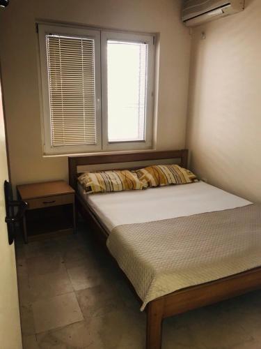 niewielka sypialnia z łóżkiem i oknem w obiekcie Apartment Igor w Budvie