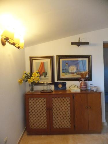 a room with a wooden cabinet with two pictures on the wall at Puerta del Arco in Riópar