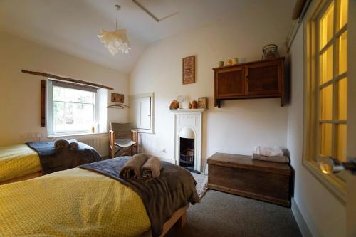 a bedroom with two beds and a fireplace at Yew Tree Cottage in Bath