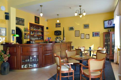 a restaurant with tables and chairs and a bar at Hotel Stefania in Krynica Zdrój