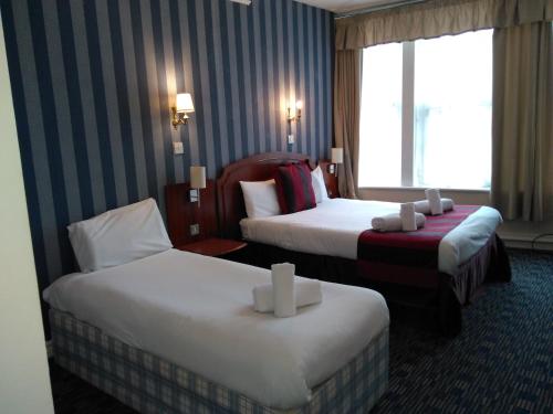 特倫特河畔斯托克的住宿－王冠酒店，酒店客房设有两张床和窗户。