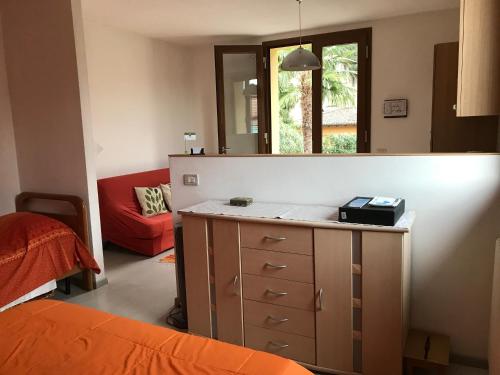 ein Schlafzimmer mit einer Kommode mit einem Spiegel und einer roten Couch in der Unterkunft Casa Pini in Griante Cadenabbia
