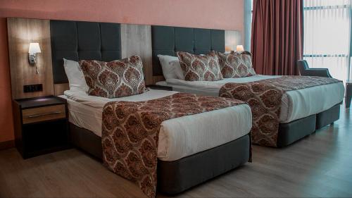 a hotel room with two beds in a room at Euphoria Batumi Convention & Casino Hotel in Batumi