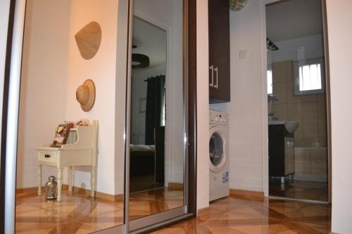 a kitchen with a glass door and a washing machine at Relax Apartament in Constanţa