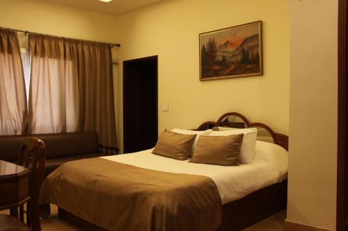 a bedroom with a bed and a chair and a window at Lamedina Hotel & Resort in Jounieh