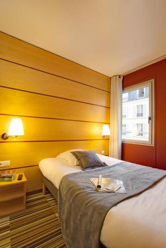 une chambre d'hôtel avec un lit et une fenêtre dans l'établissement Belambra Clubs & Hotels - Le Magendie, à Paris
