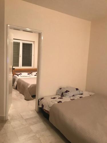 sypialnia z 2 łóżkami i lustrem w obiekcie Apartment Igor w Budvie