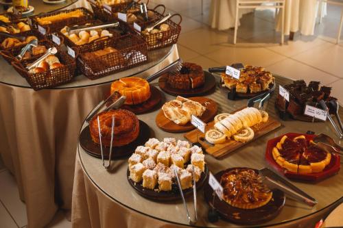 eine Auslage verschiedener Gebäcksorten auf einem Tisch in der Unterkunft Pousada Le Sapê in São Lourenço