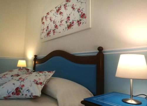 a bedroom with a bed and two lamps and a painting at TENUTA ALMATELLUS in Torre Lapillo