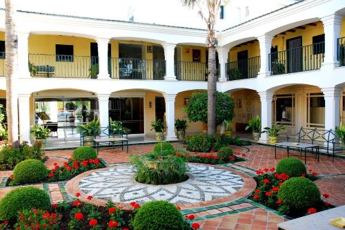 a courtyard of a building with a flower garden at Los Monteros Marbella Hotel & Spa in Marbella