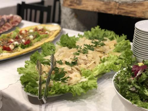 a table topped with a salad and a plate of food at Resort Big House Plitvička jezera in Ličko Petrovo Selo