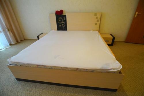 a bed in a room with a white mattress at Квартира in Kamianske