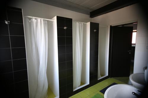 a bathroom with black and white shower curtains at Sportpension Ostromeč in Velký Malahov
