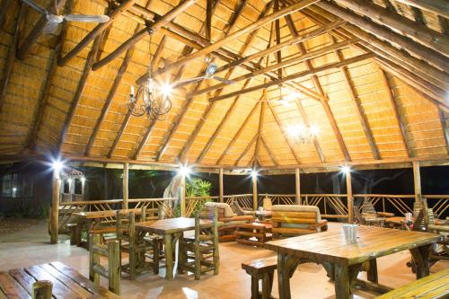 un grand bâtiment en bois avec des tables et des chaises. dans l'établissement Klippan River Lodge, à Groblersbrug