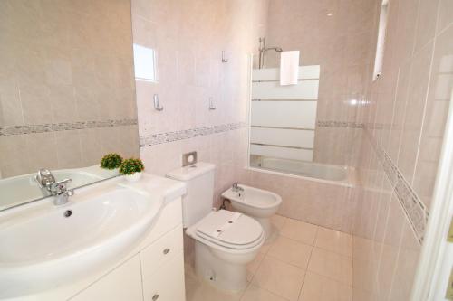 La salle de bains blanche est pourvue de toilettes et d'un lavabo. dans l'établissement Sete Rios, Near Zoo Lisboa/ free Wifi, à Lisbonne
