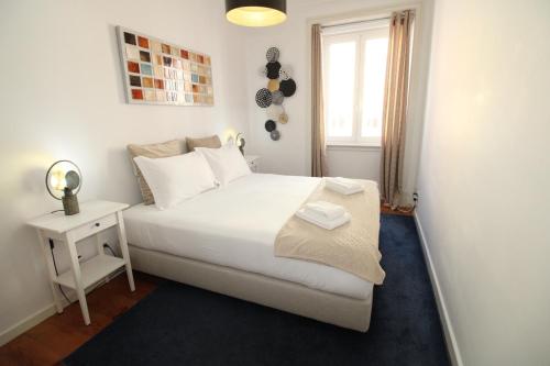 a bedroom with a white bed and a window at Sete Rios, Near Zoo Lisboa/ free Wifi in Lisbon