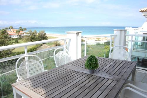 デニアにあるLes Portelles del mar 1ª línea Playaの木製テーブルと椅子、海を望むバルコニー