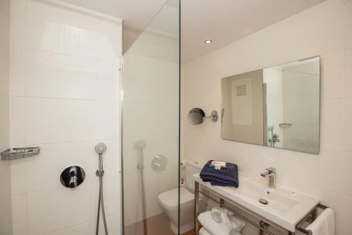 a white bathroom with a sink and a shower at Hotel Tres Torres in Santa Eularia des Riu