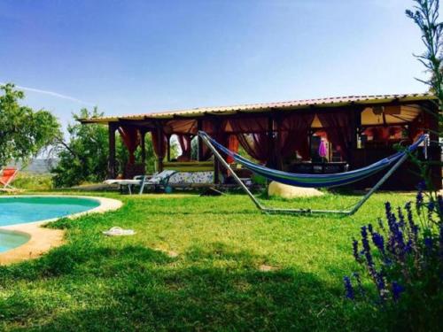a hammock in front of a house next to a pool at Apartamentos la Jayma del Arte in Asque