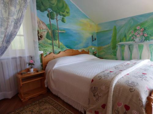 Schlafzimmer mit einem Bett mit Wandgemälde in der Unterkunft Casa Vacanze Sole in Borghetto dʼArroscia