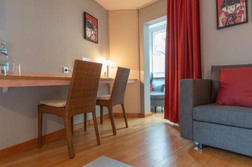 a living room with a table and chairs and a couch at Badischer Hof in Bühl