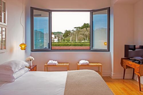 a bedroom with a bed and a window at Herdade do Ananás in Ponta Delgada