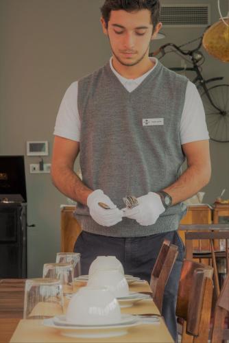 a man is standing next to a table with plates at Herdade do Ananás in Ponta Delgada