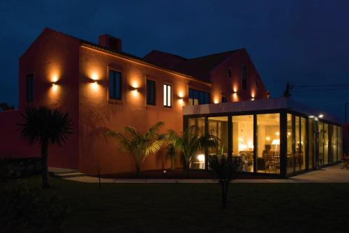 una casa con luces al costado de ella por la noche en Herdade do Ananás, en Ponta Delgada