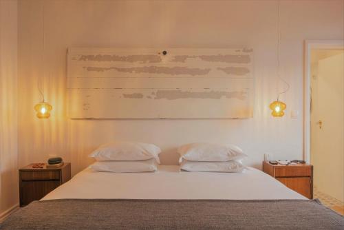 a bedroom with a bed with two pillows on it at Herdade do Ananás in Ponta Delgada