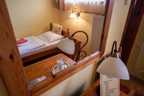 a small room with a mirror and a bed at Il Gallo Nero - Fekete Kakas Étterem és Panzió in Szombathely