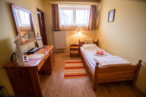 a bedroom with a bed and a desk and a mirror at Il Gallo Nero - Fekete Kakas Étterem és Panzió in Szombathely