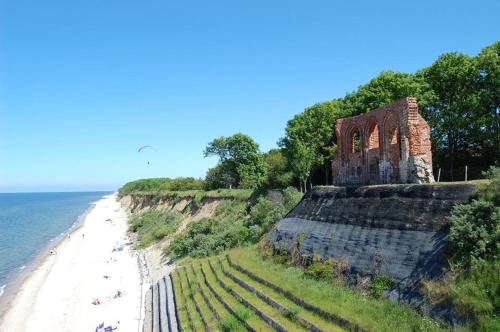 a building on the side of a cliff next to the ocean at Panorama_SPA in Trzęsacz