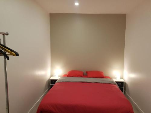 - un lit avec 2 oreillers rouges dans l'établissement 2 Pièces au coeur du quartier branché du port, à Nice
