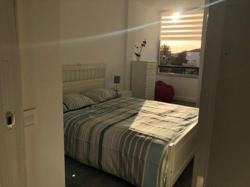 Schlafzimmer mit einem großen Bett und einem Fenster in der Unterkunft Tenerife sur, costa del silencio in Arona